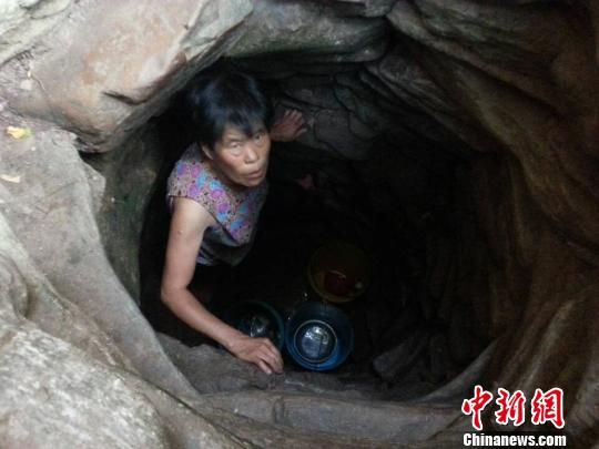 8月4日，村民在几近干枯的井下等待泉水。村民们称，取一桶水至少要等两个小时。　齐永　摄