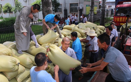 2015年07月03日，河南安阳，少林寺禅耕农场丰收，将五万斤小麦装上卡车捐赠给遭受火灾的滑县四间房乡。