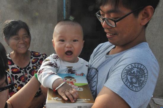 向村民发放贝因美婴童食品，保护灾后困难时期孩子的健康成长