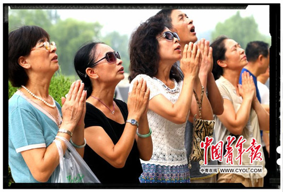 7月27日，河北省唐山地震遗址公园，唐山大地震过去40年后，人们在地震遇难者纪念墙上寻找亲人的名字，并用鲜花祭奠。中国青年报·中青在线记者 李建泉/摄
