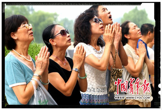 7月27日,河北省唐山地震遗址公园,唐山大地震过去40年后,人们在地震遇难者纪念墙上寻找亲人的名字,并用鲜花祭奠。中国青年报·中青在线记者 李建泉/摄