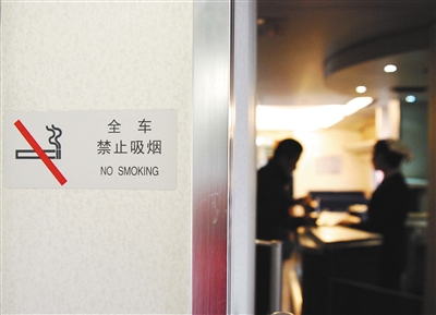2011年1月8日，江西九江车站，旅客在贴有禁烟标志的动车上购买食品。图/视觉中国