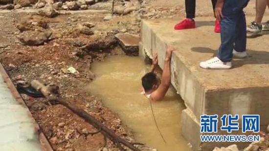 市民手机拍摄的视频截图，赵云松进入积水桥洞搜寻孩子的情形。（资料图）
