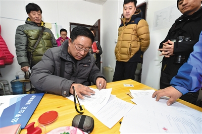 12月6日，居民在北京石景山区北辛安棚改项目南北岔公房选房分中心签约。新华社记者 张晨霖 摄