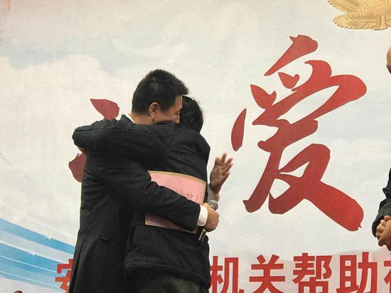 图为：中国社会福利基金会副秘书长杭宇与被资助人徐人华拥抱。