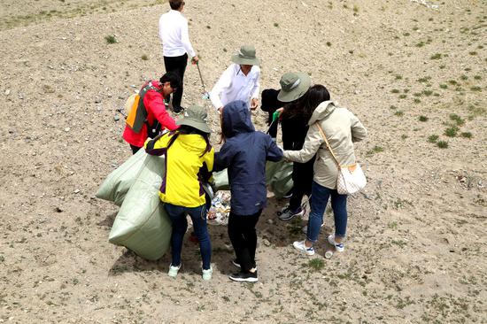 志愿者们化身“清道夫”，在青藏线清洁行动中捡拾垃圾