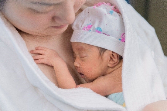 在位于成都市的四川省妇幼保健院新生儿重症监护室里，一位母亲在给自己的宝宝提供“袋鼠式护理”（KMC）。“袋鼠式护理”是“新生儿早期基本保健”（EENC）的一部分，由联合国儿童基金会在中国西部地区的项目医院试点推行。EENC包含了一系列操作简单、低成本高效的干预措施包括出生后立即彻底擦干、立即母婴皮肤接触、延迟脐带结扎、纯母乳喂养、袋鼠式护理等一系列干预措施。©UNICEF/China/2016/Ma