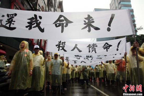 5月13日下午，台湾数百渔民聚集台北，冒着大雨在马尼拉经济文化办事处前抗议，要求菲律宾政府为攻击台渔船事件道歉、惩凶、赔偿。中新社发 董会峰 摄